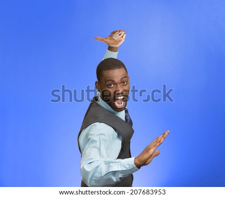 Closeup portrait angry mad furious, company man raising hands in air attack with karate chop isolated blue background. Negative human emotion facial expression feeling, body language, signs, symbols