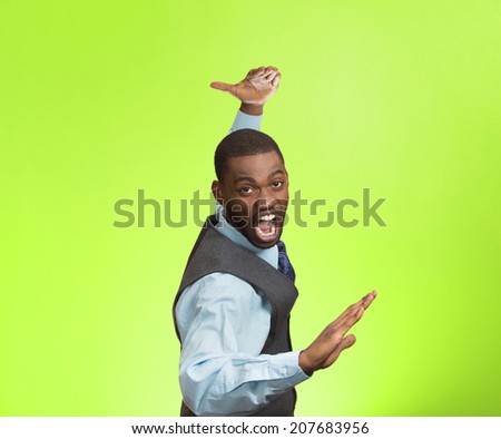Closeup portrait angry mad furious, company man raising hands in air attack with karate chop isolated green background. Negative human emotion facial expression feeling, body language, signs, symbols