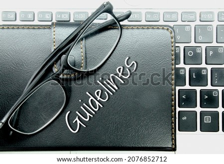 laptop keyboards, glasses and notebooks with the word guidelines