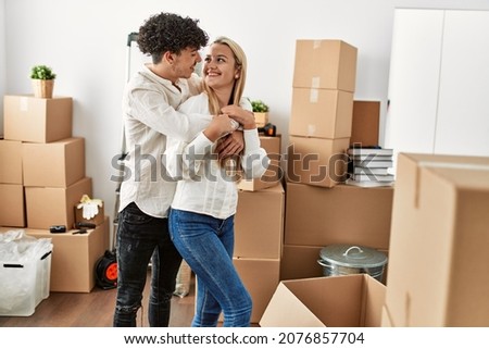 Young beautiful couple smiling happy and hugging at new home.