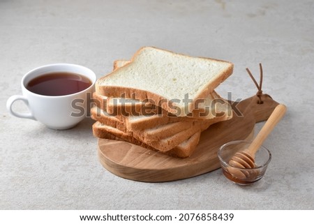 Sliced Toast Loaf White Bread (Shokupan or Roti Tawar) for Breakfast on light background. Served with honey and tea, with Bakery Concept Picture. Copy Space for Text