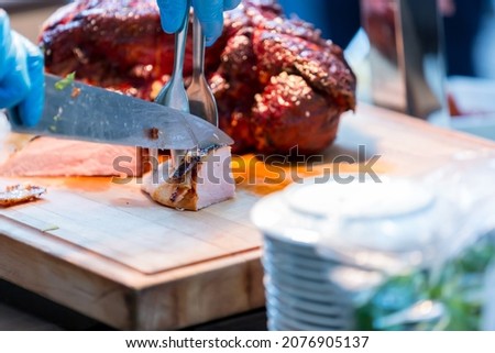 Roast pork neck. Roasted shoulder of pork on a cutting board.
