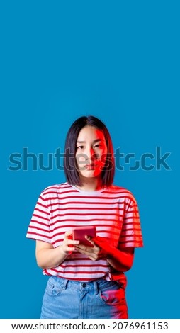 Young asian woman indoors isolated background holding smartphone looking camera - cropped banner 16:9