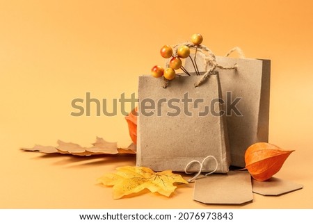 Black Friday Sale concept. Shopping paper bags, handmade tags, fall oak leaves, autumn decor. Light background, flat lay, close up Royalty-Free Stock Photo #2076973843