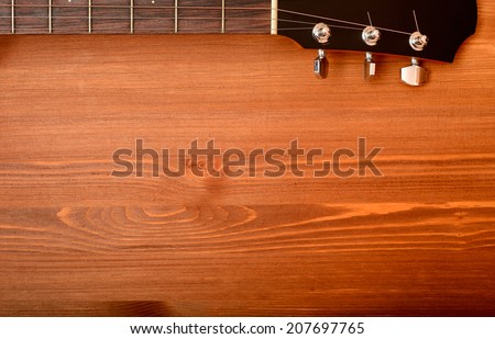 Close-up western guitar neck on wooden background