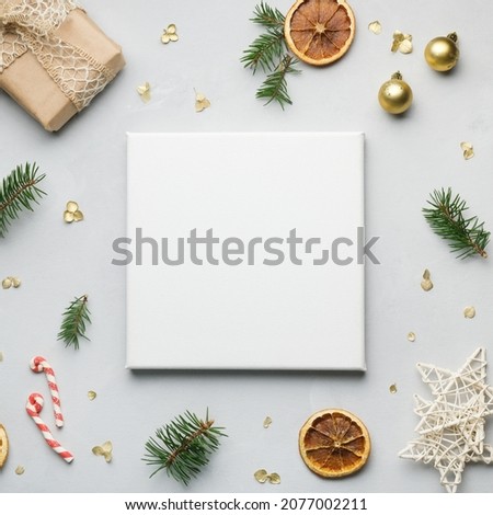 Blank frame canvas and Christmas decoration on gray background. Mockup poster, copy space for message or photo. Christmas, New Year concept. Top view.