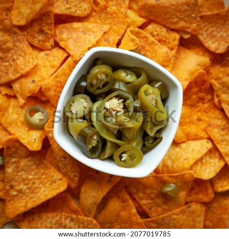 Nacho with chili pickles. Spicy peppers in bowl with corn chips.