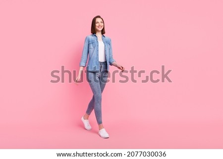 Full length body size photo girl smiling confident looking copyspace walking forward isolated pastel pink color background