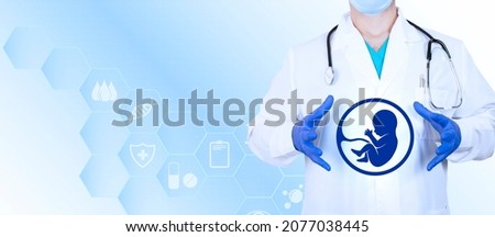 In the hands of a gynecologist, an embryo icon, as a symbol of conception and in vitro fertilization. Copy space. High quality photo Royalty-Free Stock Photo #2077038445