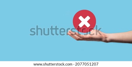 Hand holds icon,cancellation symbol,cancel icon.Cross mark flat red icon.round X mark.cancel button.Wrong.cross mark rejection.Declined.On dark background.Banner.Copy space.Place for text Royalty-Free Stock Photo #2077051207