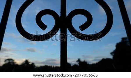 Silhouette of curved steel on blue sky background.