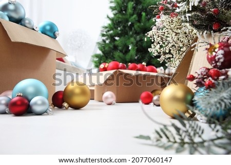 Christmas tree and cardboard boxes full of Christmas balls and decorations, preparation concept background with copy space