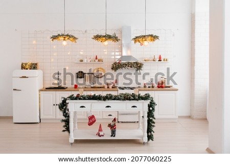 Christmas white Scandinavian kitchen interior with red decor and lights. Island table in the middle of the kitchen Royalty-Free Stock Photo #2077060225