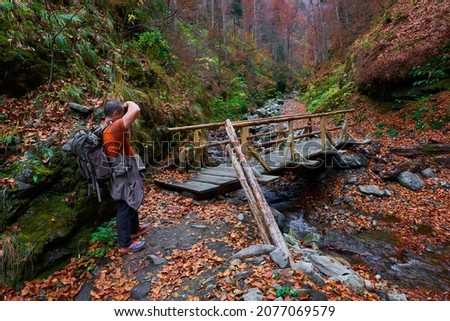 Travel photographer in a beautiful autumnal scene in the mountains