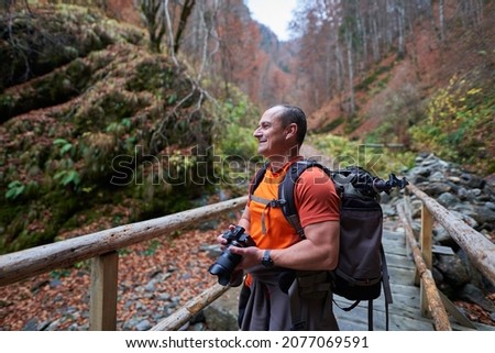 Travel photographer in a beautiful autumnal scene in the mountains