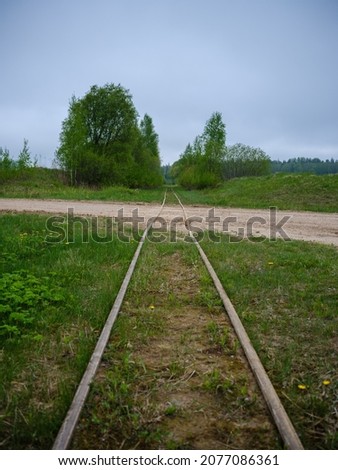 old abandoned train tracks in green meadow in summer countryside