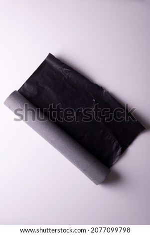 roll of black carbon paper tape on white background.
