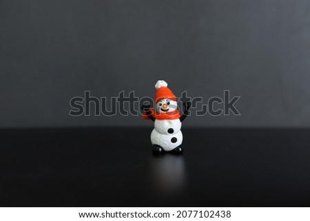 
toy snowman on a black background