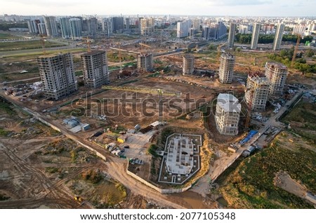 Construction site with tower crane on formworks. Crane on construction the building and multi-storey residential homes. Housing renovation concept, aerial view. Built environment. Soft focus.