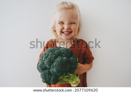 Child girl with broccoli healthy food vegan eating lifestyle organic vegetables plant based diet nutrition funny kid happy smiling  Royalty-Free Stock Photo #2077109620