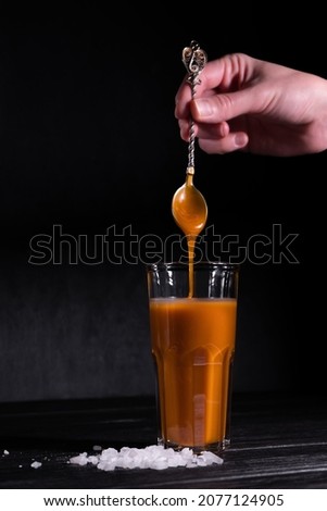 Homemade salted caramel sauce in a jar on a dark background. copy space text
