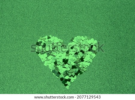 Green glitters heart on colorful background.