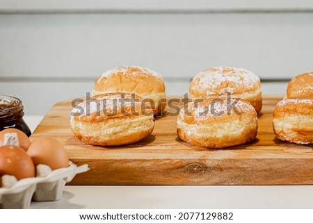 Cooking Hanukkah donuts or sufganiyot. Traditional sweets for the Jewish holiday. Fresh berliner dessert at home kitchen.