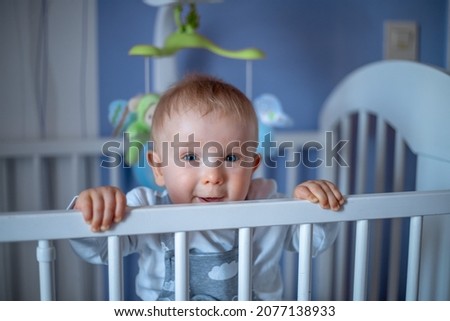 cute baby lies in a crib and smiles.