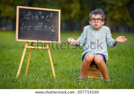 Cute little confused student  Royalty-Free Stock Photo #207714160