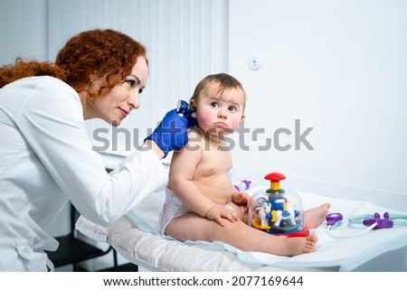 Pediatrician providing healthcare for her baby patient in the office of a specialized clinic for children. Neonatologist. Medical appointment little child one year old in the clinic.  Royalty-Free Stock Photo #2077169644