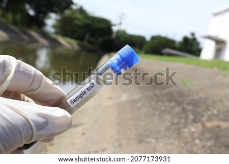 Collect samples of wastewater from industrial canals in test tubes to be examined in the laboratory