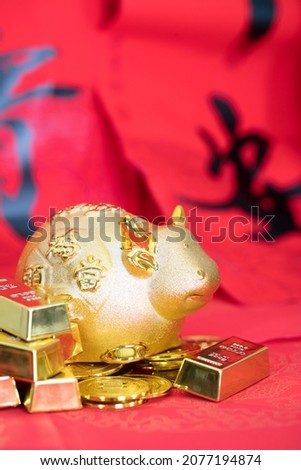 Taurus and gold on red background.The Chinese characters in the picture mean "peace and wealth"