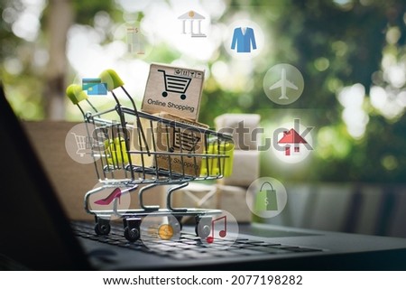 Online shopping e-commerce and customer experience concept : Boxes with shopping cart on a laptop computer keyboard, depicts consumers buyers buy or purchase goods and service from home or office