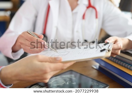 Female doctor and patient signing medical contract