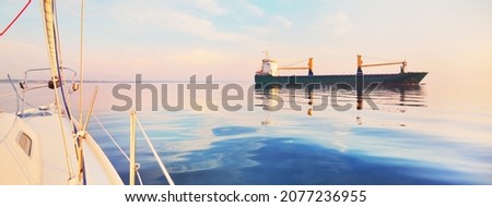 Large cargo ship sailing in the Baltic sea at sunset. Soft golden sunlight. Concept seascape. Panoramic view from the sailing boat. Freight transportation, nautical vessel, logistics Royalty-Free Stock Photo #2077236955