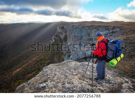 Nature photographer traveler taking photo of beautiful morning landscape from top of the mountain