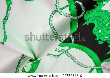 Silk fabric in black, white and green colors. Heraldic shield with angel wings and ribbons for medieval design - Print on canvas. Texture background pattern.
