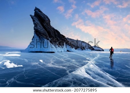The guy is skating on the ice of Lake Baikal. Winter Siberian landscape.