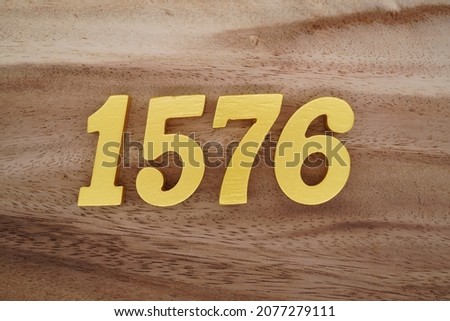Golden Arabic numerals 1576 on a dark brown to white wood grain background.