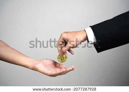 Businessman giving golden bitcoin to another man. two hands exchanging cryptocurrency. Royalty-Free Stock Photo #2077287928