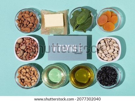 A set of natural products rich in vitamin E. Healthy food concept. Cardboard sign with the inscription. Green background. Royalty-Free Stock Photo #2077302040