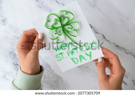 Diy St. Patricks Day greeting card made of Quilling and paper clovers on white background. Gift idea, decor Spring, happy Patrick Day. Step by step. Top view. Process kid children craft Do it yourself