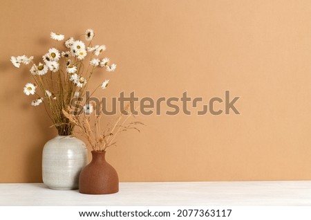 Beautiful bouquets of dry plants against a brown wall