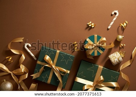 Top view of christmas ornament in brown background , gift box with yellow ribbon and twinkle yellow pearl with middle blank space for holiday 