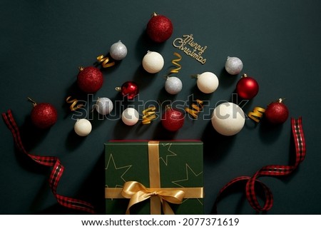 Dark blue background with suprise gift box full of christmas ornament , candy red ribbon colorful twinkle pearl , christmas holiday content