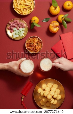 Chinese lunar new year with mandarin orange holiday with beer celebrate candy and jam , flower and red pocket , yellow background photography Tet holiday content , chinese new year