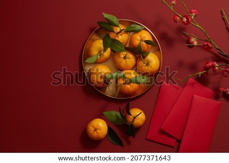 Chinese lunar new year with mandarin orange , flower and red pocket in red background , photography Tet holiday content , top view