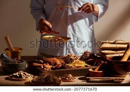 Traditional chinese medicine with herb and spices in brown wooden background and a doctor for advertising , chinese traditional medicine content  Royalty-Free Stock Photo #2077371670