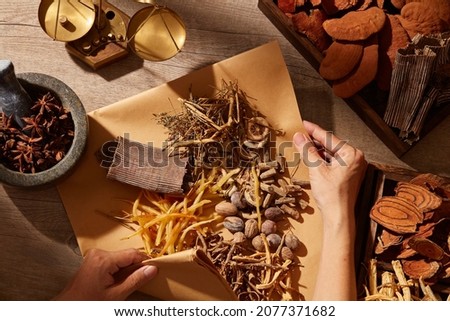 Traditional chinese medicine with herb and spices in brown wooden background mortar and pestile with a pack of medicine , for medicine advertising , photography traditional medicine content