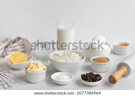 Ingredients for baking on a white background. Baking ingredients background. Ingredients for making dough, cakes, muffins, pies, side view. Royalty-Free Stock Photo #2077386964